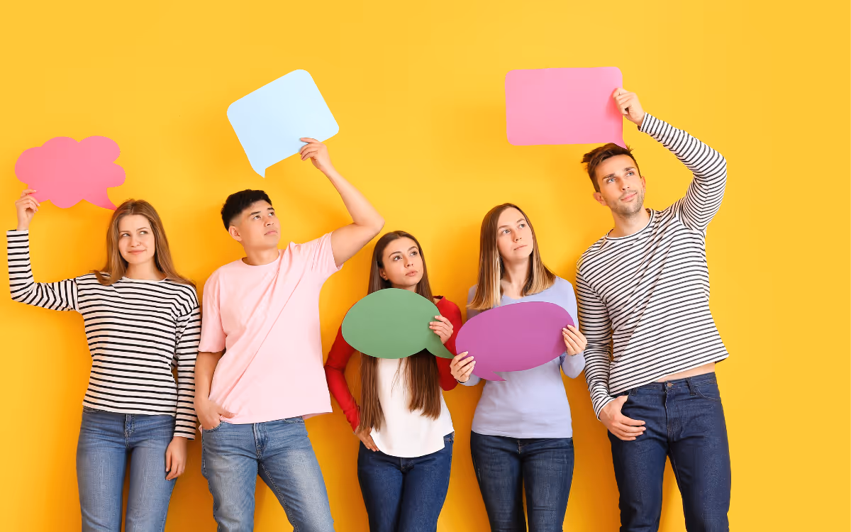 Five people holding paper speech bubbles in various positions.